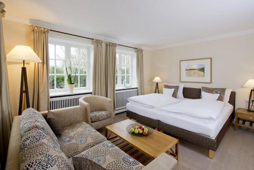a hotel room with two beds and a couch at Benen-Diken-Hof in Keitum