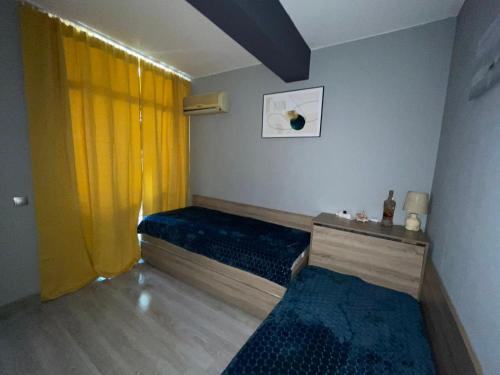 um quarto com duas camas e uma cortina amarela em Апартамент Havana Beach St Vlas em Sveti Vlas