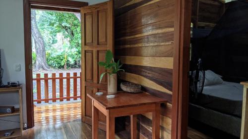 a room with a wooden wall and a table with a plant at Wood Cabin - Cabana Maderas in Balgue