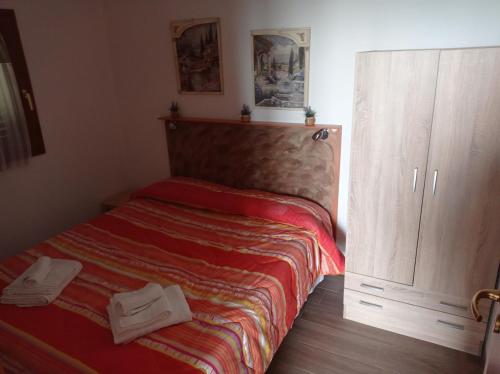 a small bedroom with a bed and a cabinet at oasi macerina in Alanno