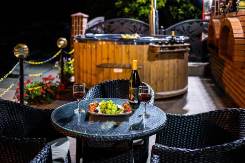 a table with a bowl of fruit and wine glasses at PENSIUNEA MIHAELA-Transalpina in Novaci