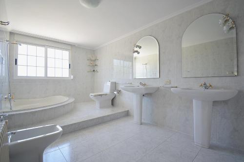 a bathroom with two sinks and a tub and a toilet at Casa con jardín en Vilanova de Arousa in Pontevedra