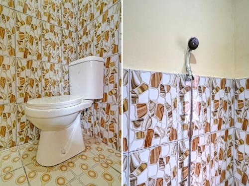 a bathroom with a toilet and a shower curtain at OYO 91389 Anggrek Residence Syariah in Lebakwangi