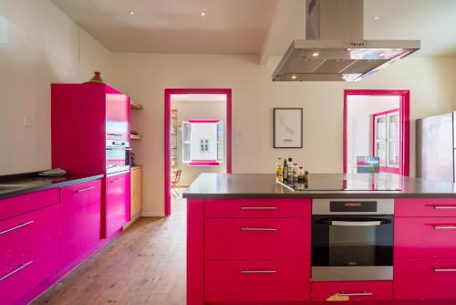 a kitchen with red cabinets and black counter tops at Wynwood Boutique Hotel in Willemstad