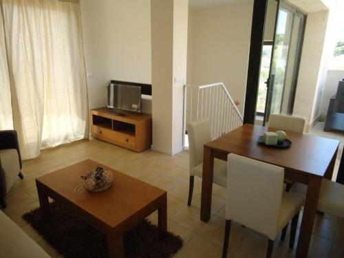 a living room with a dining table and a television at Casa Patrick in Murcia