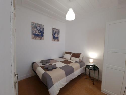 ナザレにあるCasa Pisa Flores - Praia da Nazaréのベッドルーム1室(大型ベッド1台付)が備わります。壁には2枚の写真が飾られています。