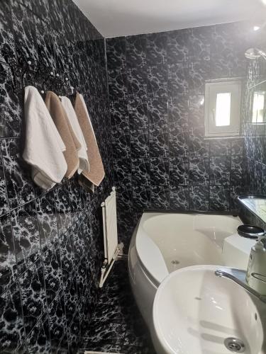 a black and white bathroom with a sink and a toilet at Montana Slănic in Slănic-Moldova