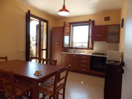 a kitchen with a wooden table and a dining room at Marsala Casa Vacanza Villetta in Marsala