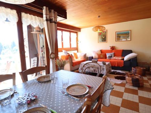 un salon avec une table et un canapé dans l'établissement Les Gets - Appartement Calme Proche Centre, Parking, WiFi - FR-1-623-29, aux Gets