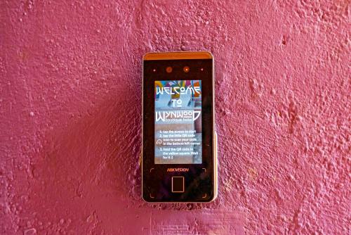a cell phone is hanging on a pink wall at Wynwood Boutique Hotel in Willemstad