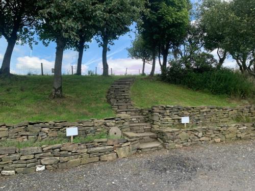 an old stone wall on the side of a field at Luxury traditional stone farmhouse in Saddleworth in Oldham
