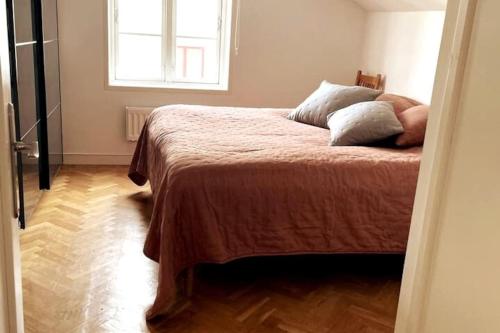 sypialnia z łóżkiem i oknem w pokoju w obiekcie Central lägenhet i nyrenoverat 1700-talshus w mieście Västervik
