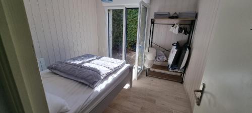 Habitación pequeña con cama y ventana en Location vacances Morbihan Questembert, en Questembert