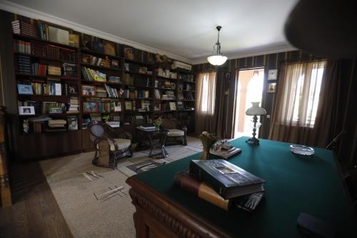 a room with a library with a desk with books at Casa de Khasia in Zugdidi