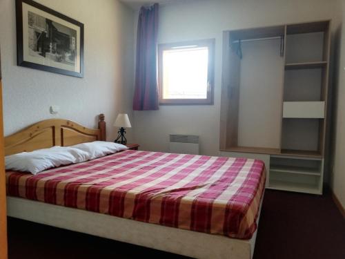 - une chambre avec un grand lit et une couverture rayée dans l'établissement Appartement lumineux 2 pièces cabine pour 6 personnes avec balcon à Merlette, Orcières - FR-1-636-96, à Orcières
