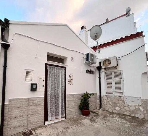 a white house with a door and a window at La lammia di Pisticci in Pisticci