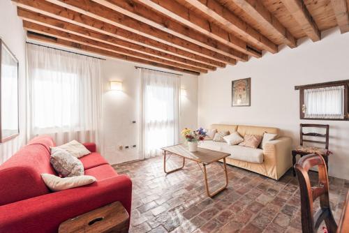 a living room with a red couch and a table at Country house Viaro_150sqm in Vanzo