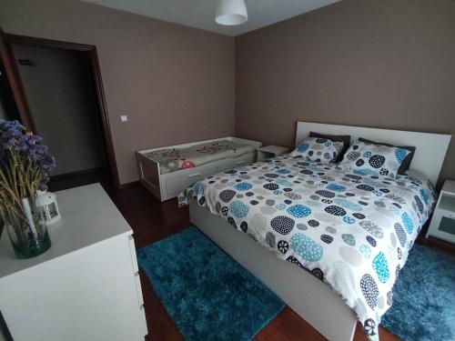 a bedroom with a bed with a blue rug at Casa da Quinta in Capela