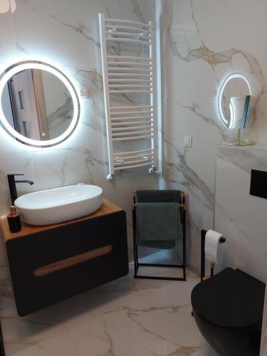 a bathroom with a sink and a mirror at Porta Mare Marine in Dziwnów