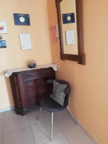 a chair sitting next to a vanity with a mirror at Blanca Apartments in Guayaquil