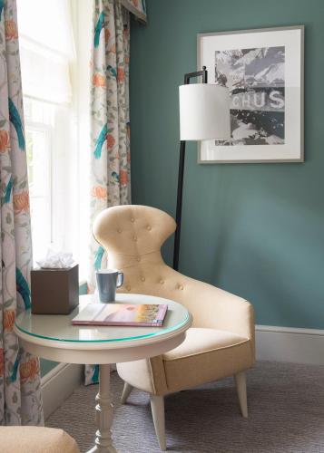 a room with a table and a chair and a lamp at Bush Hotel Farnham in Farnham