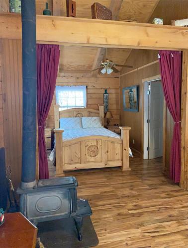 a bedroom with a bed in a log cabin at A Peace of Heaven Cabins and RV in Vanderpool