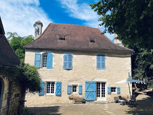 Lanzac的住宿－Auberge du lion d'or，一座大型砖砌建筑,上面有蓝色百叶窗
