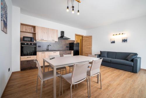 a kitchen and living room with a table and chairs at Cauriol Suites 1.1 in Cavalese