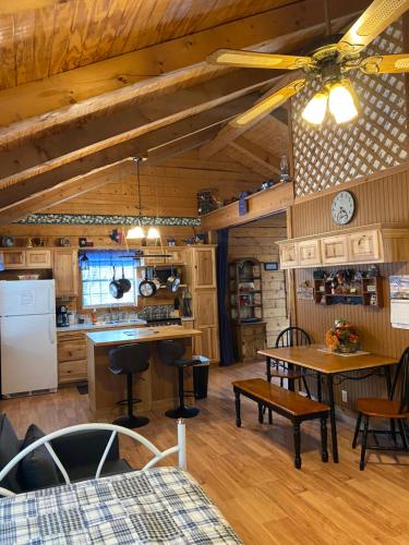 a kitchen and dining room with a ceiling fan at A Peace of Heaven Cabins and RV in Vanderpool