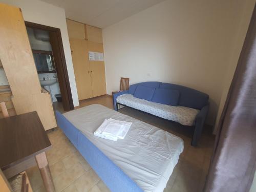 ヴェンティミリアにあるCase Vacanze Stellaのベッド1台とソファが備わる小さな客室です。