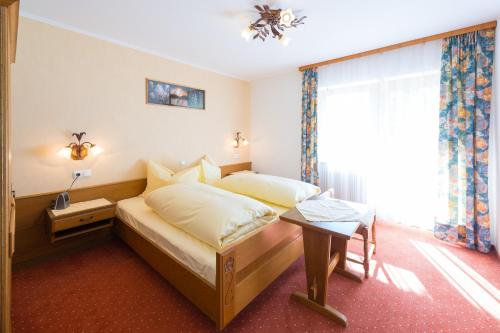 ein Hotelzimmer mit einem Bett und einem Fenster in der Unterkunft Haus Enzian in Lermoos