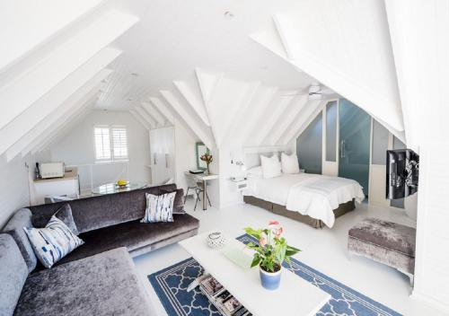 a living room with a bed and a couch at Admiralty Beach House in Port Elizabeth