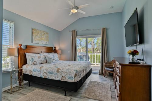 a bedroom with a bed and a flat screen tv at Athenas Cottage in Butler Beach