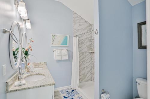 un bagno con doccia, lavandino e WC di Walk to Beach with Private Pool, Balconies & Huge Lawn Blocks to Dining a Butler Beach