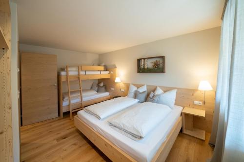a bedroom with two bunk beds and a ladder at Oberzerod Apartments in Siusi
