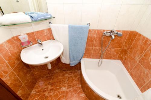 a bathroom with a sink and a toilet and a tub at Apartments Vitorin in Sobra