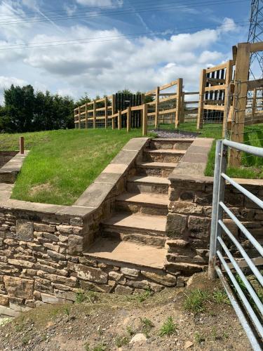 a set of stone steps with a wooden fence at Unique Barn conversion in Saddleworth in Oldham