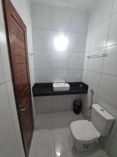 a small bathroom with a toilet and a sink at Duplex de 2 quartos com ar condicionado , piscina e estacionamento in Aracati