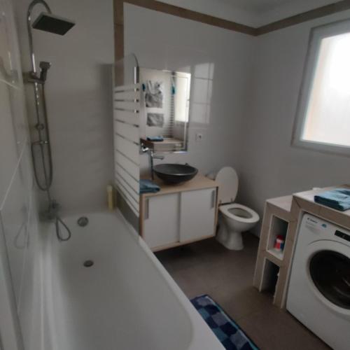 une salle de bain avec une baignoire, un lavabo et des toilettes dans l'établissement Maison 3 chambres. cour Privative 2 places de parking privatives, à Corquilleroy