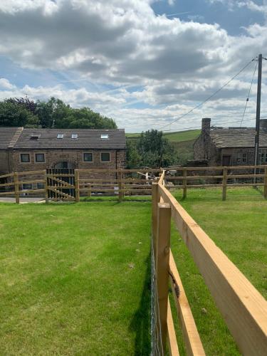 a horse in a field behind a fence at Unique Barn conversion in Saddleworth in Oldham