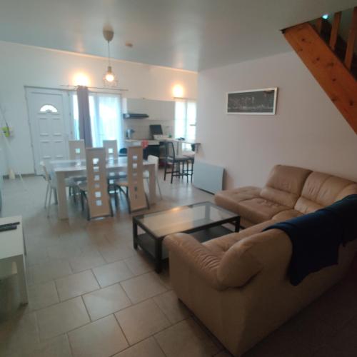 un salon avec un canapé et une table dans l'établissement Maison 3 chambres. cour Privative 2 places de parking privatives, à Corquilleroy
