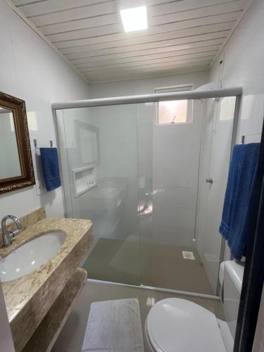a bathroom with a shower and a sink and a toilet at Pousada Recanto do Neca in Florianópolis