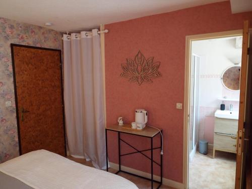 a bedroom with a bed and a table and a door at Au coeur du Volcantal in Laveissière