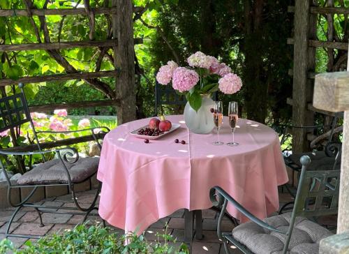 a pink table with a vase of flowers and fruit at Pleasant Apartments in Bled