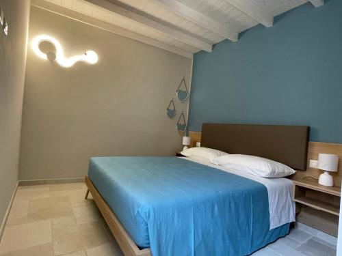 Un dormitorio con una cama con una manta azul. en Il Ginepro en Vico nel Lazio