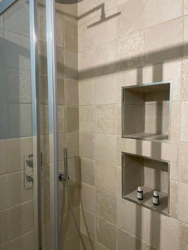 een douche met een glazen deur in de badkamer bij Il Ginepro in Vico nel Lazio