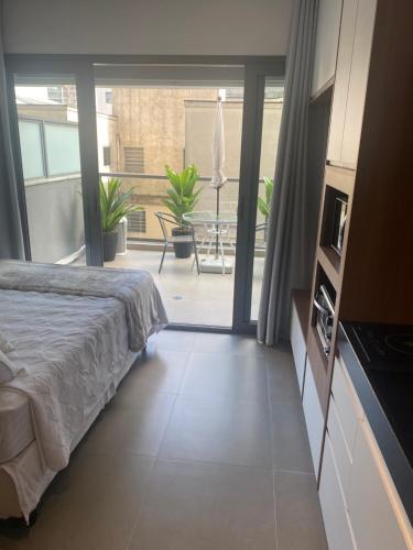 - une chambre avec un lit et une vue sur une terrasse dans l'établissement VN Oscar Freire - O Melhor de Pinheiros, à São Paulo