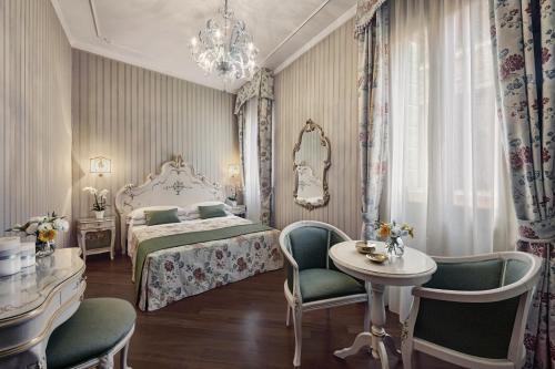 a bedroom with a bed and a table and chairs at Antica Locanda al Gambero in Venice