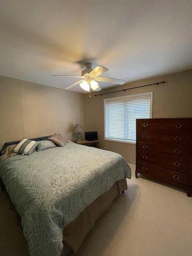a bedroom with a bed and a ceiling fan at Libby's Cove in Carsonville