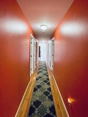 an empty hallway with red walls and a carpet at Libby's Cove in Carsonville